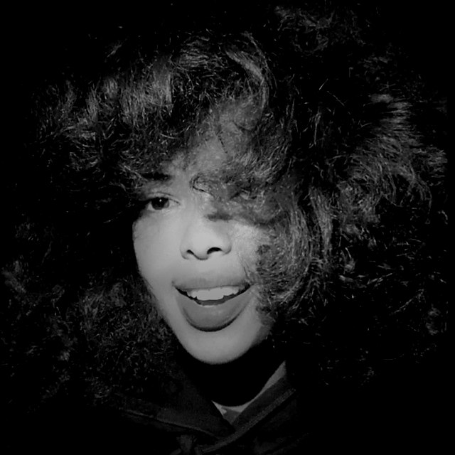 Close-up portrait of Amen, the Afrofeast brand ambassador, smiling with her curly hair across her face, Ethiopia