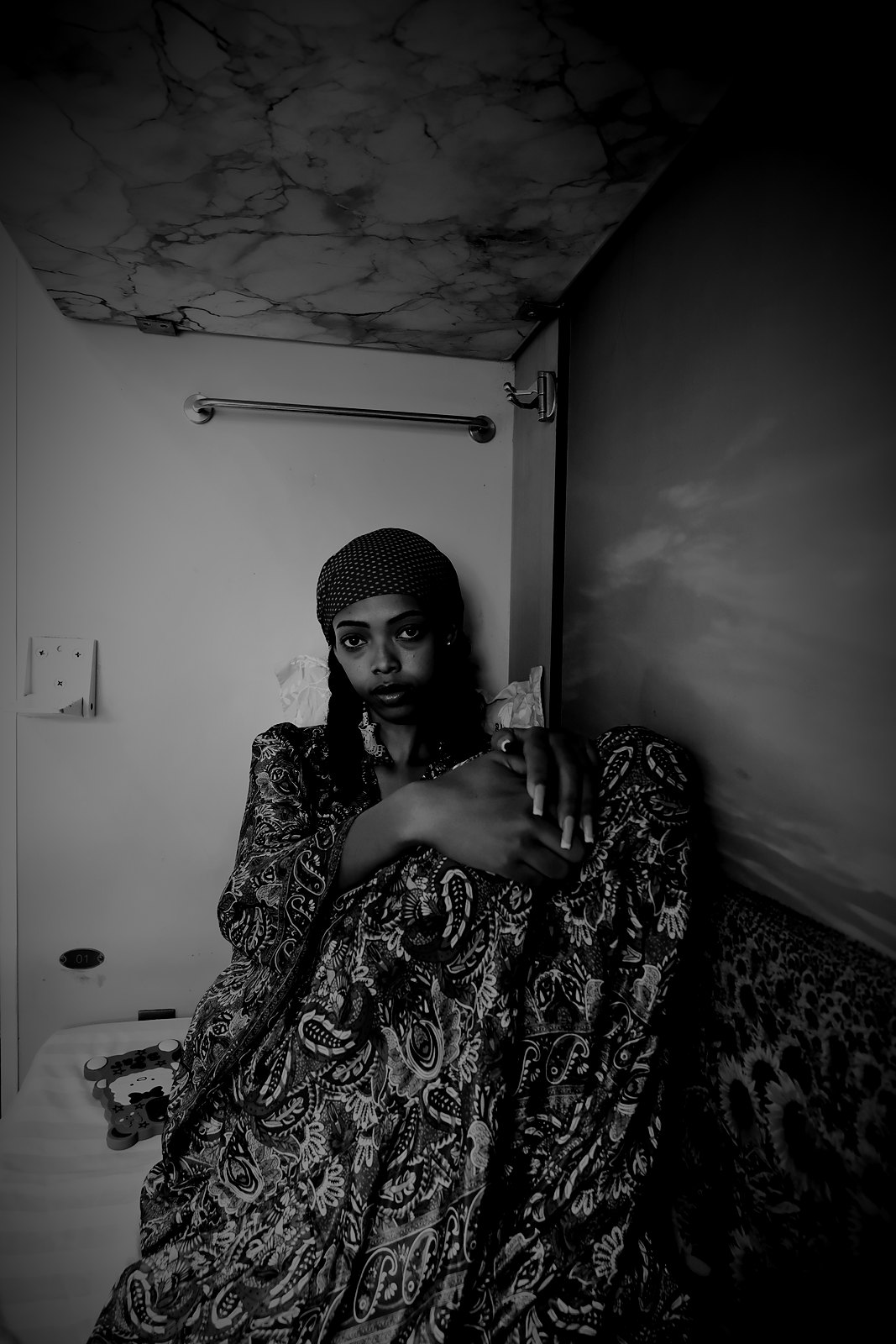 Amen, the Afrofeast brand ambassador, sitting in a patterned dress and red headscarf in a sleeper-train berth in Vietnam