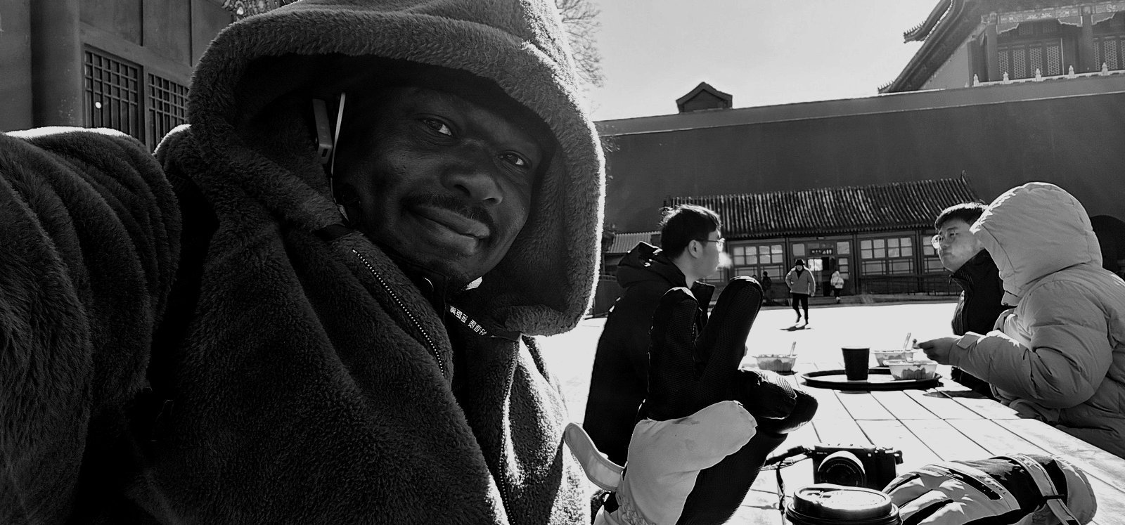 Dennis Obel having coffee on a winter morning in the Forbidden City, Beijing, China — black-and-white photograph, February 2026.