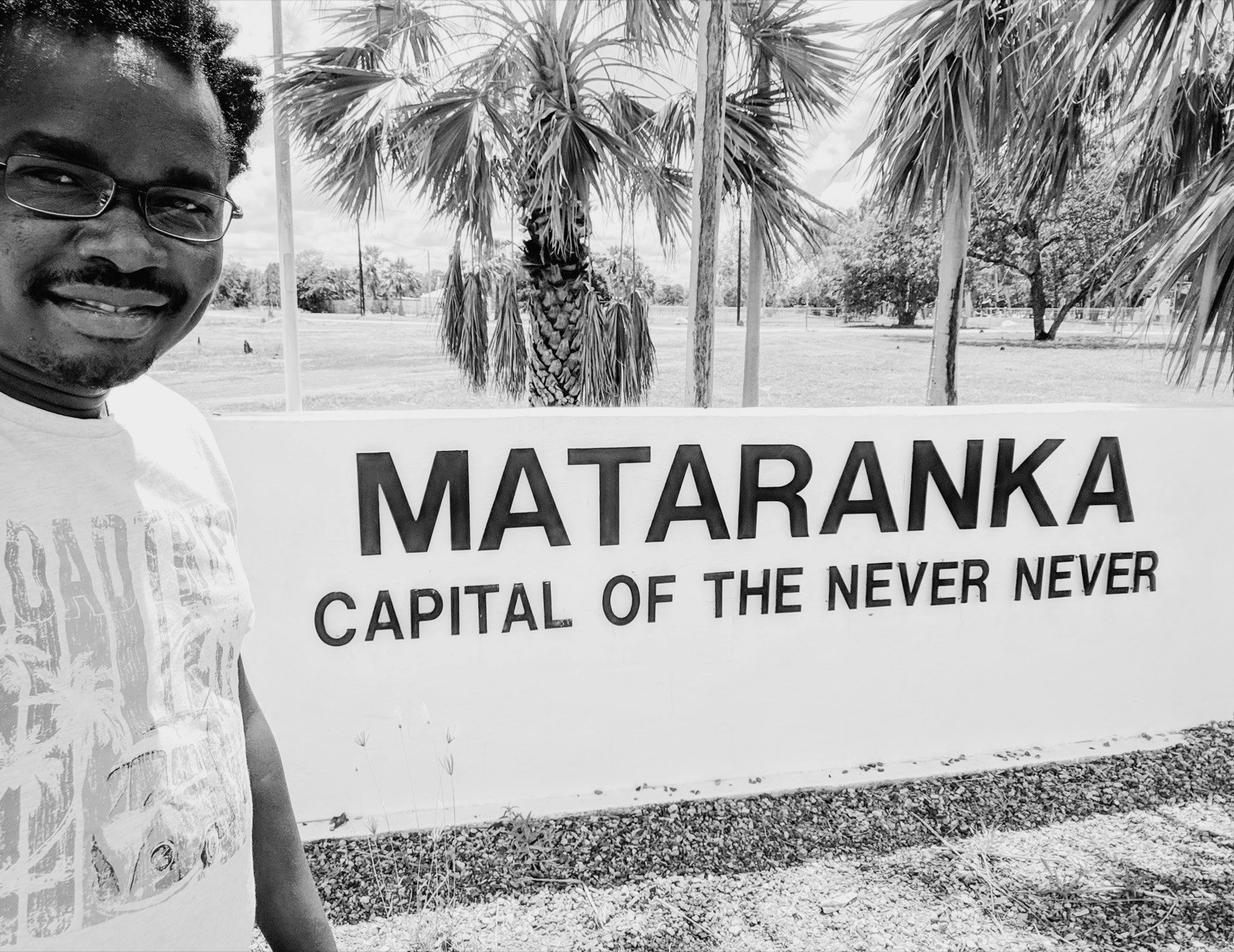 Dennis Obel at the Mataranka 'Capital of the Never Never' sign, Northern Territory outback, Australia