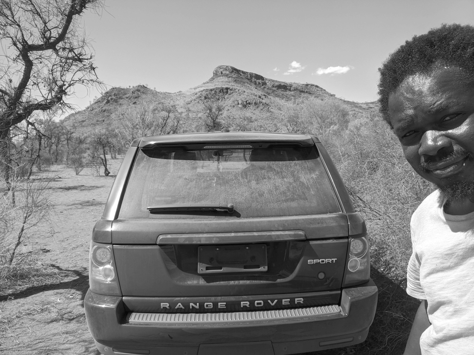 Dennis Obel beside his Range Rover Sport in the red-dirt outback, Northern Territory, Australia